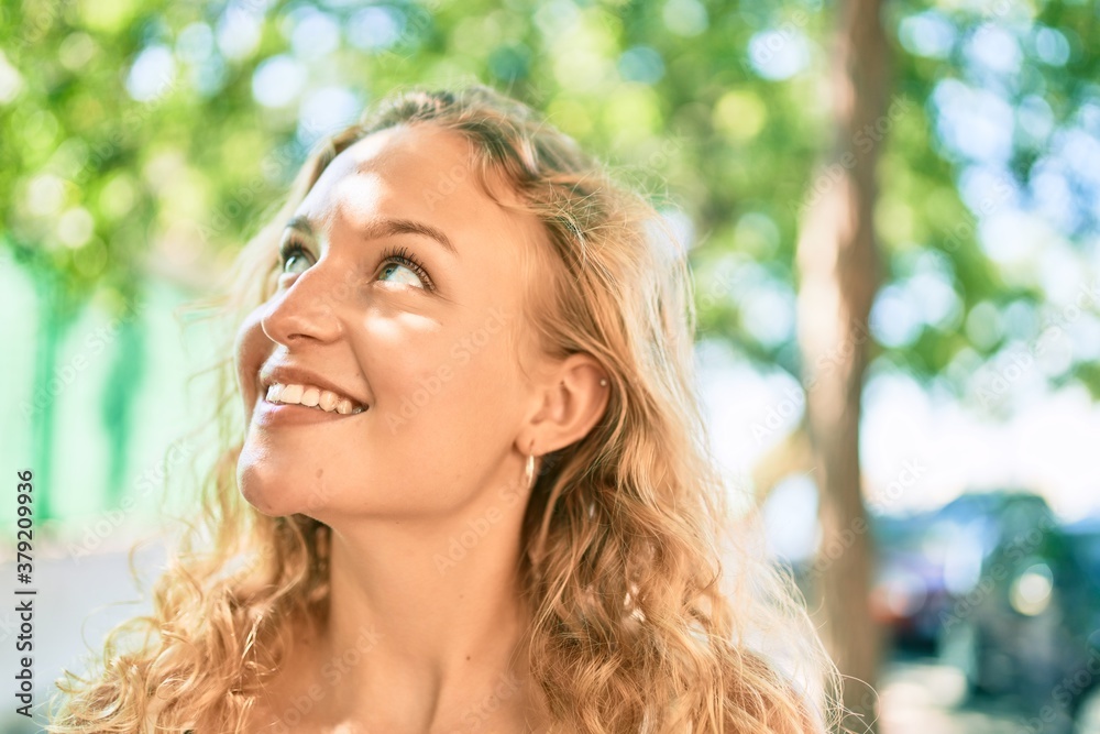 Young beautiful caucasian woman with blond hair smiling happy outdoors on a summer day