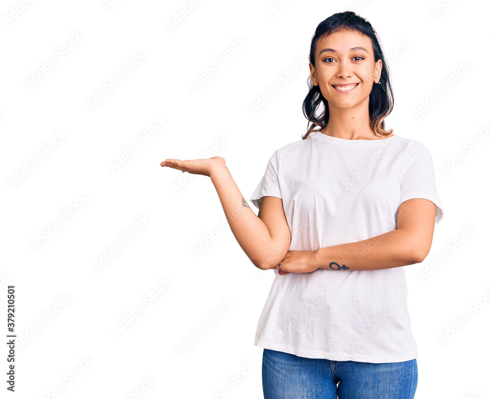 Young woman wearing casual clothes smiling cheerful presenting and pointing with palm of hand looking at the camera. Young woman wearing casual clothes smiling cheerful presenting and pointing with palm of hand looking at the camera.