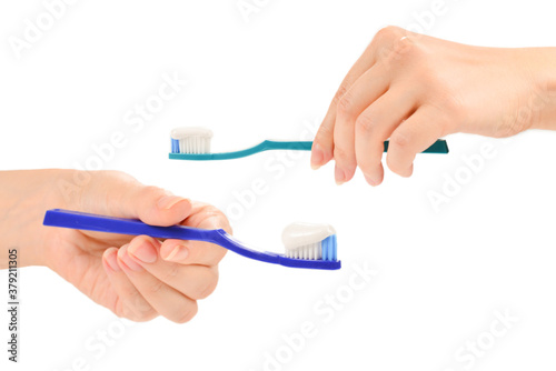 Woman holds toothbrush with toothpaste in her hand isolated on white background.