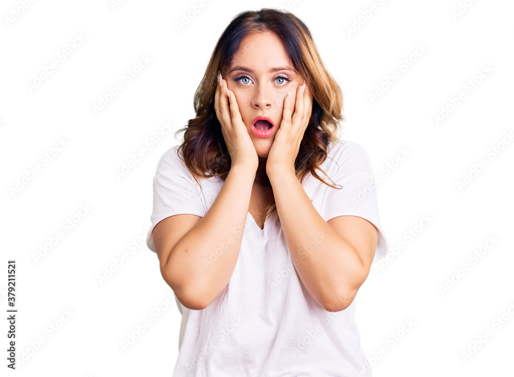 Young beautiful caucasian woman wearing casual white tshirt afraid and shocked, surprise and amazed expression with hands on face Young beautiful caucasian woman wearing casual white tshirt afraid and shocked, surprise and amazed expression with hands on face