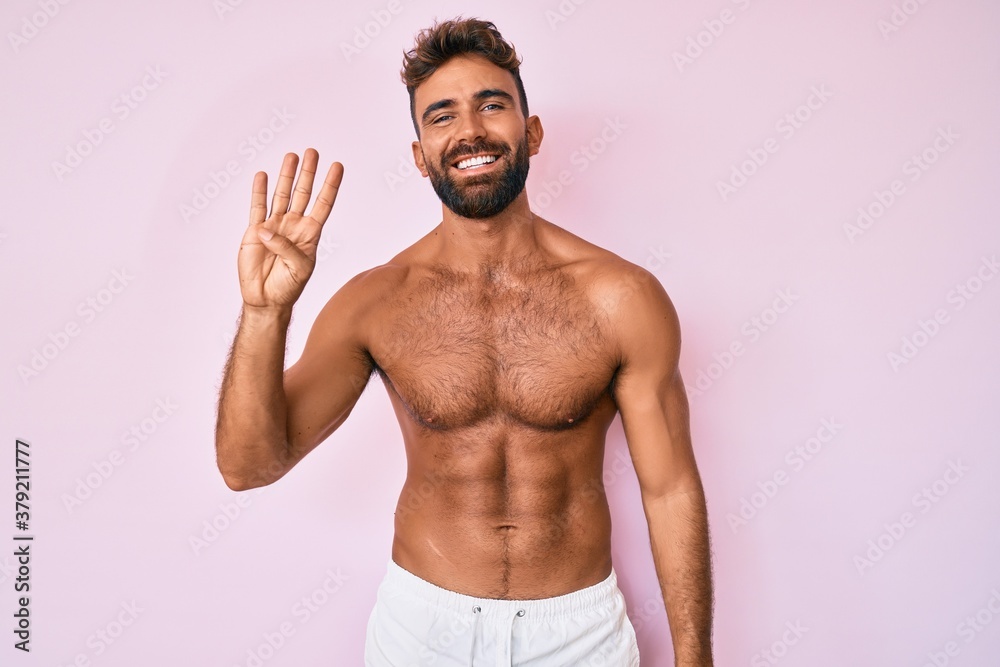 Young hispanic man standing shirtless showing and pointing up with fingers number four while smiling confident and happy. Young hispanic man standing shirtless showing and pointing up with fingers number four while smiling confident and happy.