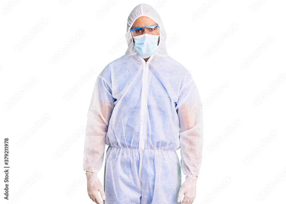 Young hispanic man wearing doctor protection coronavirus uniform and medical mask skeptic and nervous, frowning upset because of problem. negative person.