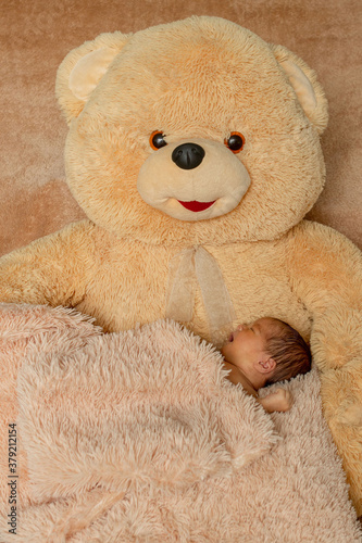 Two week old newborn baby sleeping on teddy bear © volody10