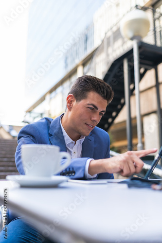 Businessman Sitting in a Cafe Using Laptop.