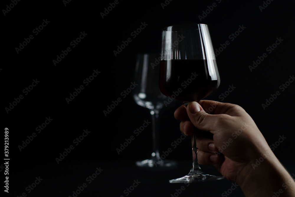 glasses with red wine on a dark background. photograph of wine in a low key. glasses with red wine on a dark background. photograph of wine in a low key.