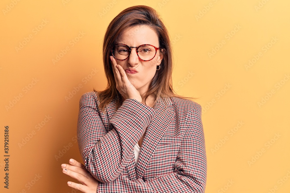 Young beautiful woman wearing business clothes and glasses thinking looking tired and bored with depression problems with crossed arms.