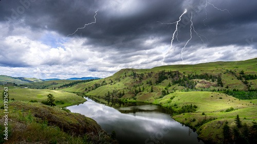 Lightning Strikes from Dark Clouds over Napier Lake in the Grasslands along Highway 5A between Kamloops and Merritt in British Columbia, Canada photo