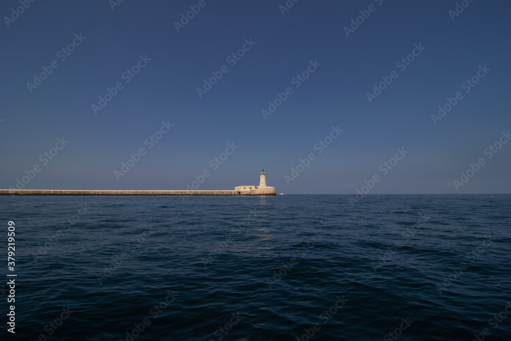 lighthouse by valetta city. ligthouse at sea. Grand Harbor at the City of Valletta, Malta. boatt background lighthouse by valetta city. ligthouse at sea. Grand Harbor at the City of Valletta, Malta. boatt background