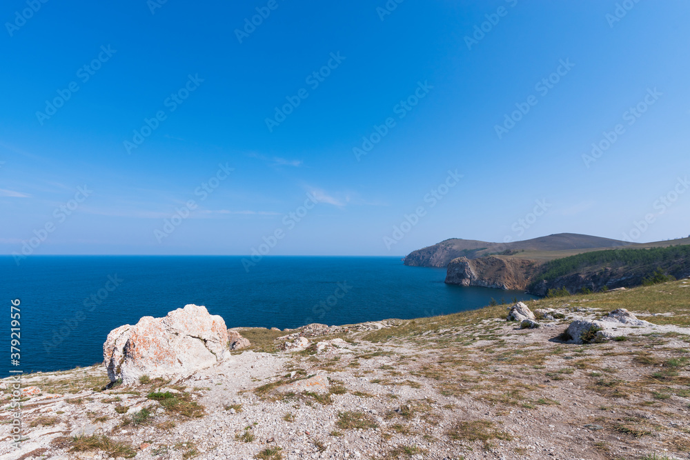 Mountain landscape of Olkhon island. Blue sky over the Maloye More Strait and cape Khoboi. View from cape Sagan Khushum..