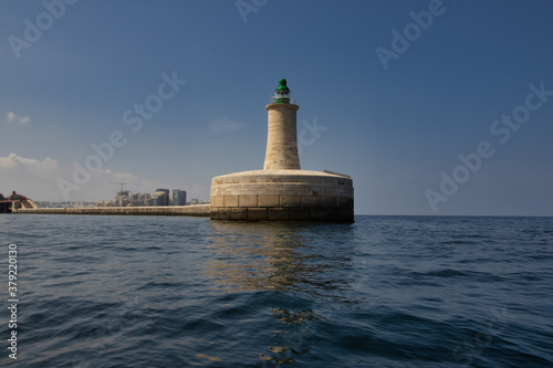 lighthouse by valetta city. ligthouse at sea. Grand Harbor at the City of Valletta, Malta. boatt background