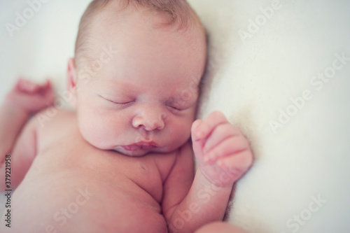 Satisfied baby sleeping on a blanket. Portrait of newborn baby.