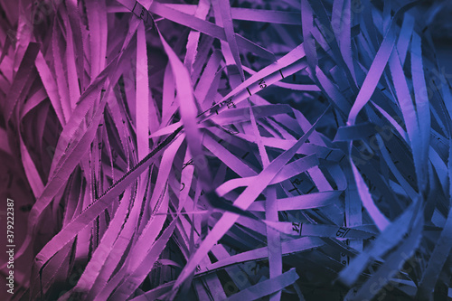 paper cut into stripes in a chaotic pile purple color blurred image, shredder