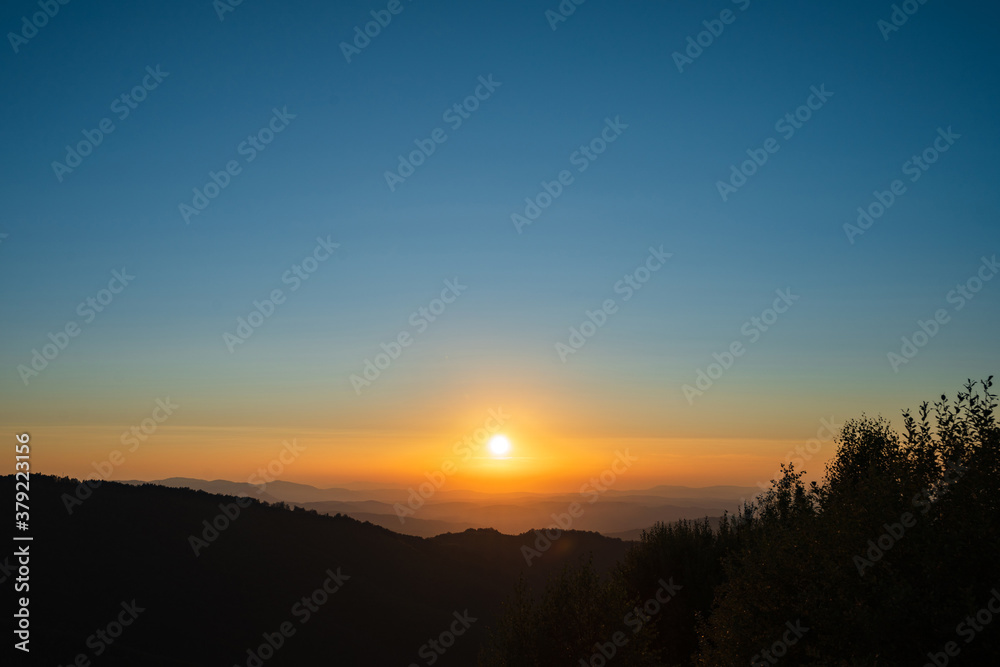 Mountain landscape in sunrise or sunset dark hills with golden sun and blue sky - freedom nature tourist destination concept - stara planina Old Mountain in Serbia