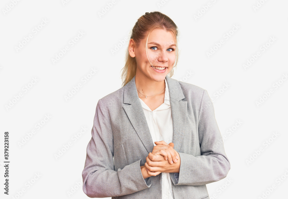 Young beautiful blonde woman wearing elegant jacket with hands together and crossed fingers smiling relaxed and cheerful. success and optimistic