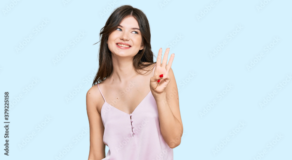 Young beautiful caucasian girl wearing casual clothes showing and pointing up with fingers number three while smiling confident and happy. Young beautiful caucasian girl wearing casual clothes showing and pointing up with fingers number three while smiling confident and happy.
