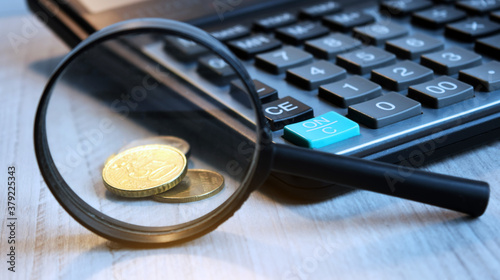 Conceptual image, Business accessories, magnifying glass, manners and calculator on the office desk. Soft focus. Black and white.
