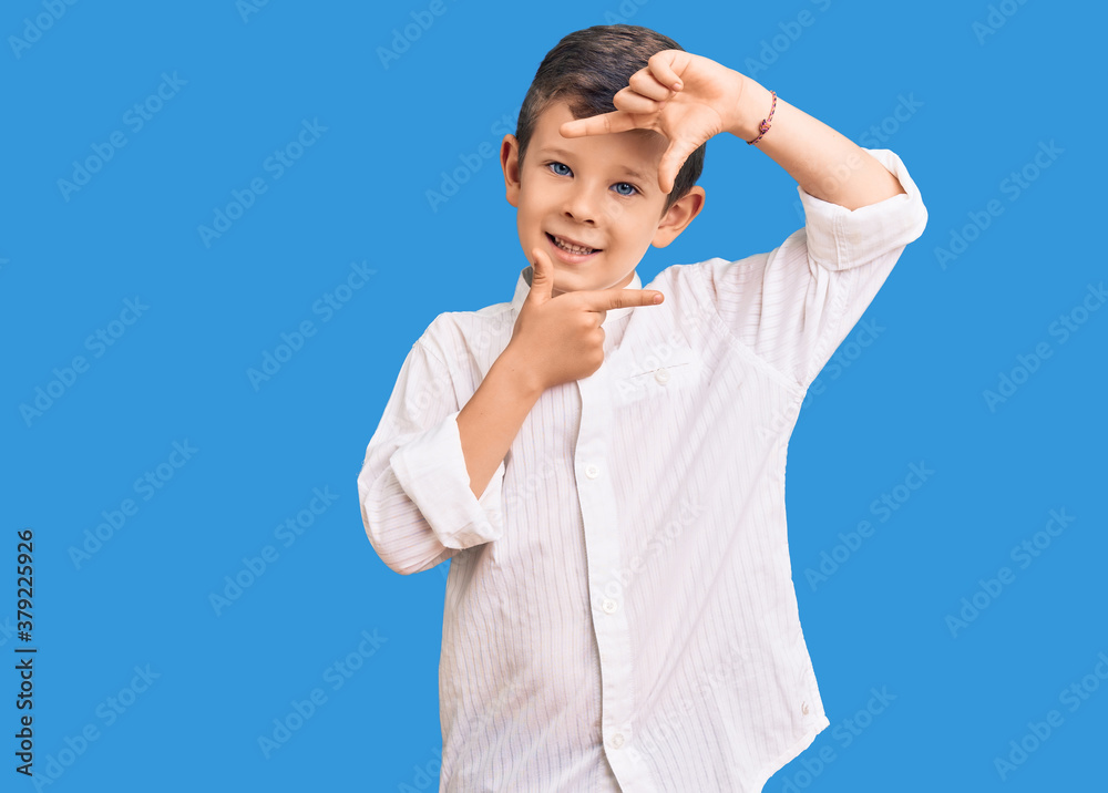 Cute blond kid wearing elegant shirt smiling making frame with hands and fingers with happy face. creativity and photography concept.