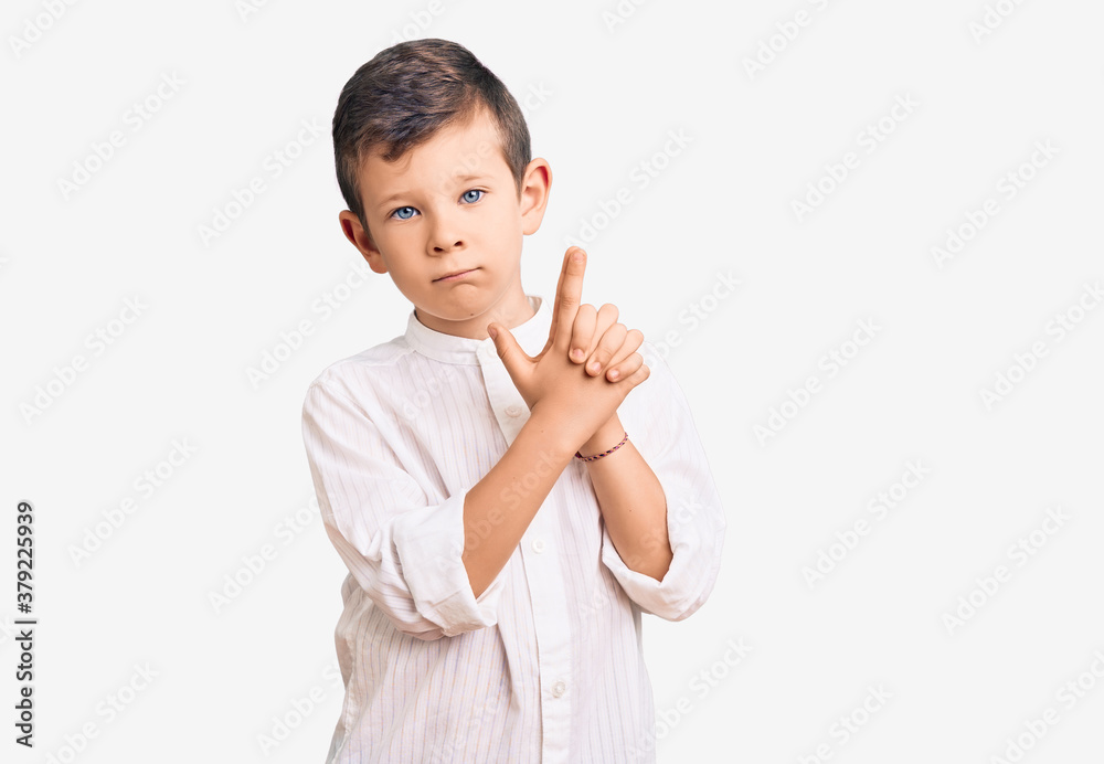 Cute blond kid wearing elegant shirt holding symbolic gun with hand gesture, playing killing shooting weapons, angry face Cute blond kid wearing elegant shirt holding symbolic gun with hand gesture, playing killing shooting weapons, angry face