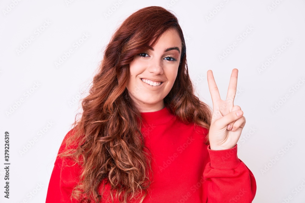 Young beautiful woman wearing casual clothes showing and pointing up with fingers number two while smiling confident and happy. Young beautiful woman wearing casual clothes showing and pointing up with fingers number two while smiling confident and happy.