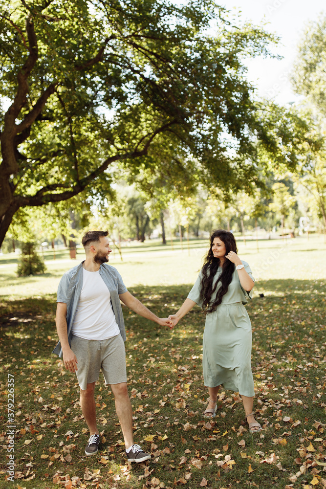 Fototapeta premium Lovely couple smiling in the garden. Wife and husband holding each other in the beautiful place. Happy marriage concept.