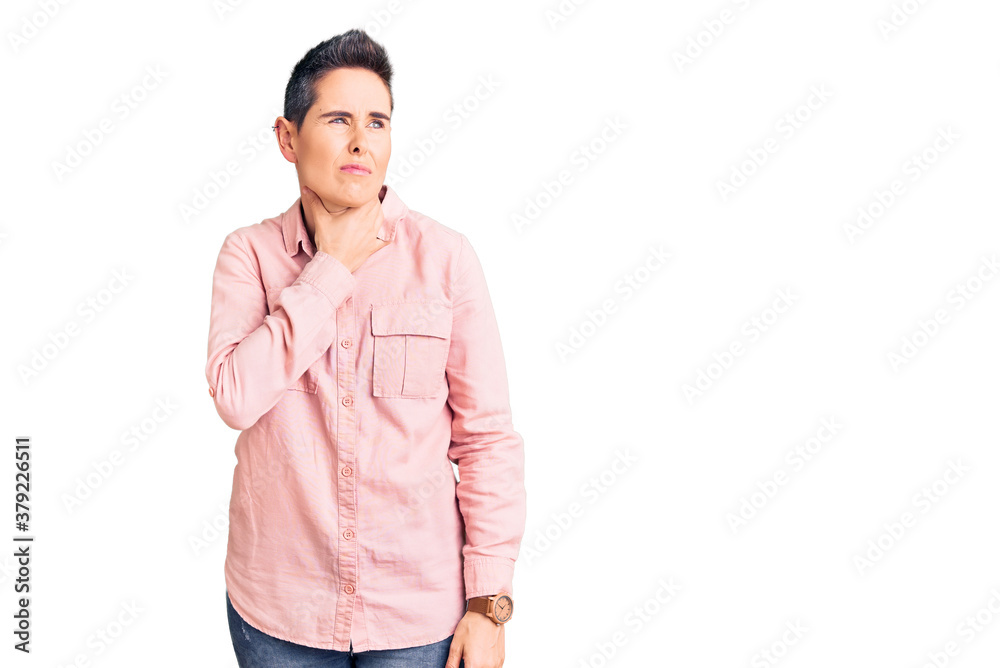 Young woman with short hair wearing casual clothes touching painful neck, sore throat for flu, clod and infection Young woman with short hair wearing casual clothes touching painful neck, sore throat for flu, clod and infection