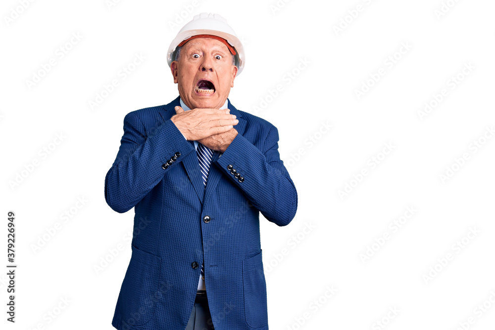 Senior handsome grey-haired man wearing suit and architect hardhat shouting and suffocate because painful strangle. health problem. asphyxiate and suicide concept. Senior handsome grey-haired man wearing suit and architect hardhat shouting and suffocate because painful strangle. health problem. asphyxiate and suicide concept.