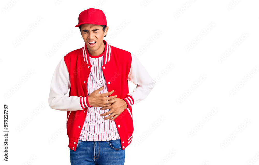 Young african amercian man wearing baseball uniform with hand on stomach because nausea, painful disease feeling unwell. ache concept. Young african amercian man wearing baseball uniform with hand on stomach because nausea, painful disease feeling unwell. ache concept.