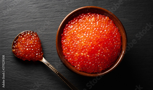 Red caviar in pot on stone plate.