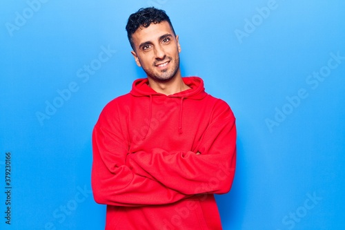 Young hispanic man wearing casual clothes happy face smiling with crossed arms looking at the camera. positive person.
