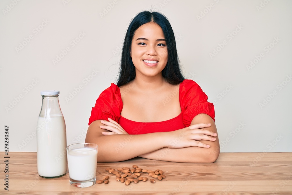 Young asian girl drinking healthy almond milk with a happy and cool smile on face. lucky person. Young asian girl drinking healthy almond milk with a happy and cool smile on face. lucky person.