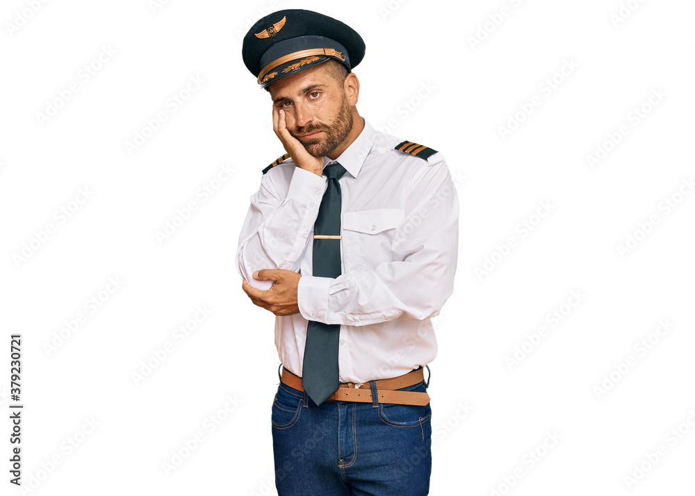 Handsome man with beard wearing airplane pilot uniform thinking looking tired and bored with depression problems with crossed arms. Handsome man with beard wearing airplane pilot uniform thinking looking tired and bored with depression problems with crossed arms.