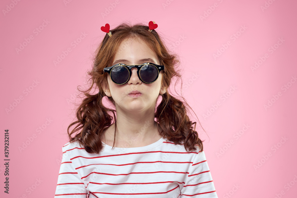 Cute girl sunglasses striped t-shirt lifestyle fun style pink background Cute girl sunglasses striped t-shirt lifestyle fun style pink background