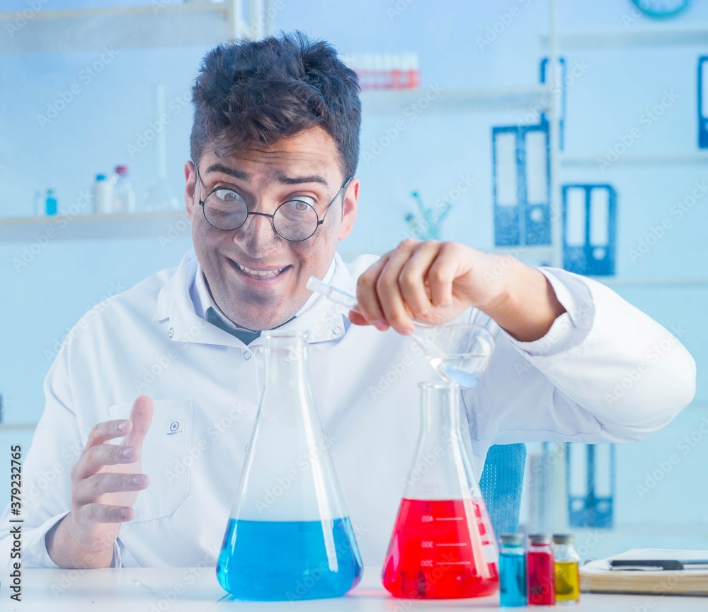 Fototapeta premium The funny mad chemist working in a laboratory
