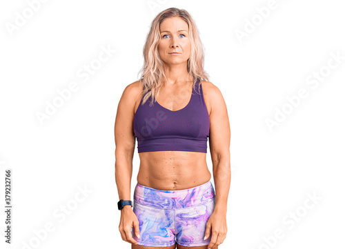 Middle age fit blonde woman wearing sportswear with serious expression on face. simple and natural looking at the camera. © Krakenimages.com