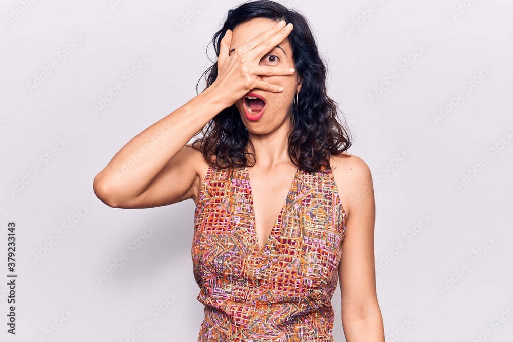 Young beautiful hispanic woman wearing casual clothes peeking in shock covering face and eyes with hand, looking through fingers afraid Young beautiful hispanic woman wearing casual clothes peeking in shock covering face and eyes with hand, looking through fingers afraid