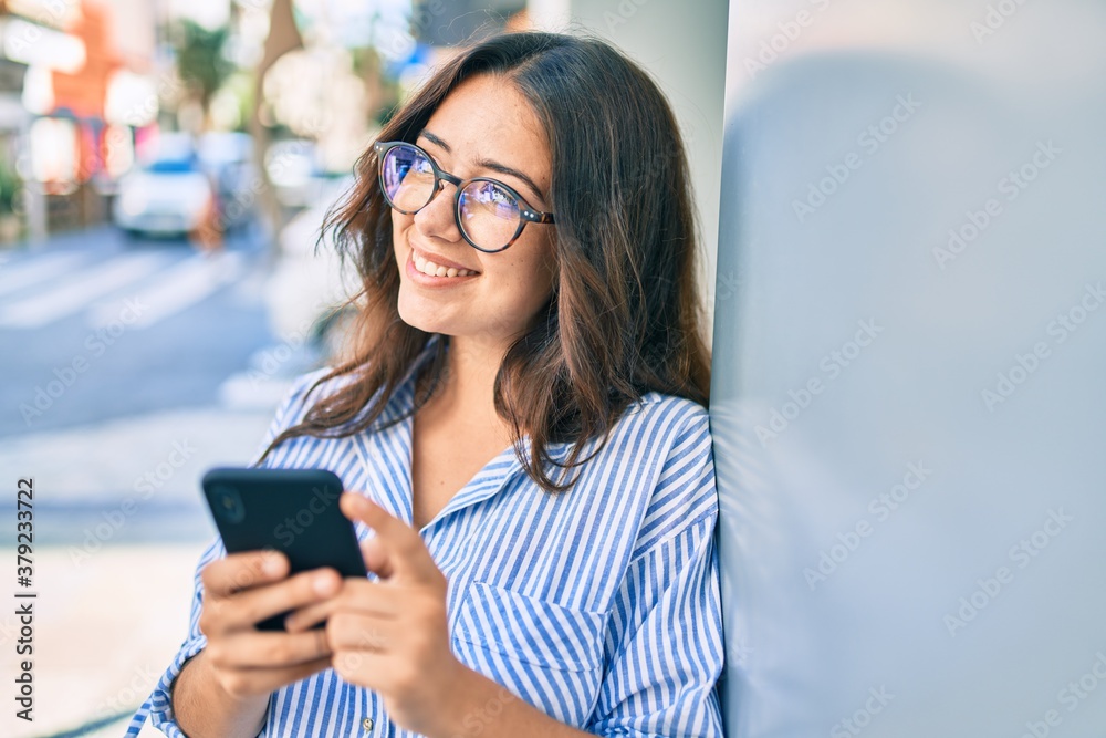 Young hispanic businesswoman smiling happy using smartphone at the city. Young hispanic businesswoman smiling happy using smartphone at the city.