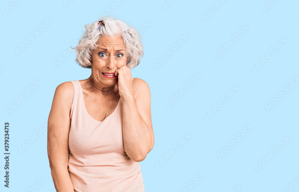 Senior grey-haired woman wearing casual clothes looking stressed and nervous with hands on mouth biting nails. anxiety problem.