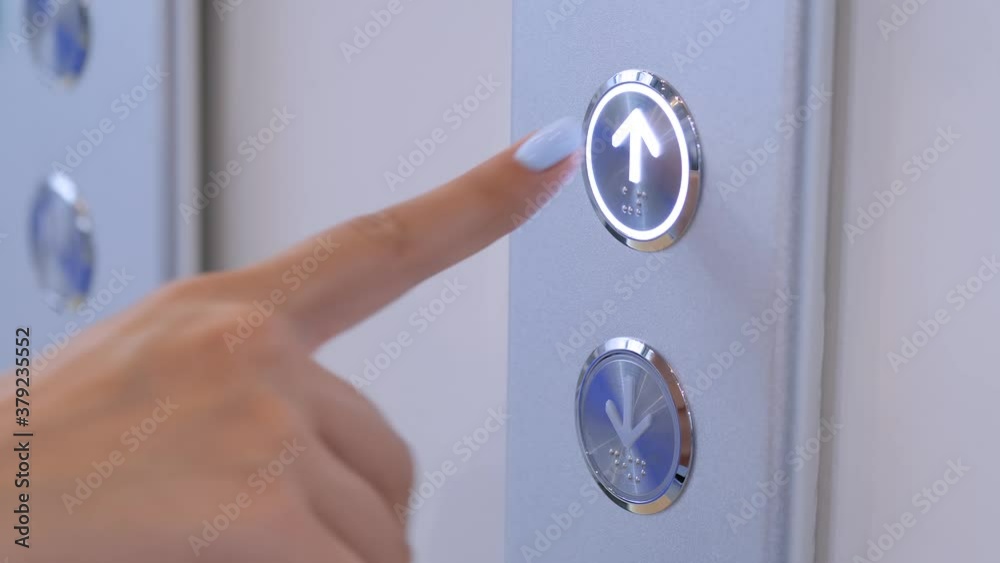 Woman finger pressing elevator up button on lift control panel at mall, hotel or business center - close up view, slow motion. Technology, moving up, progress, growth and success concept