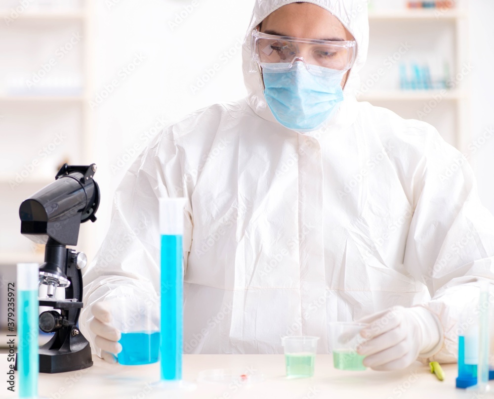 Young chemist student working in lab on chemicals