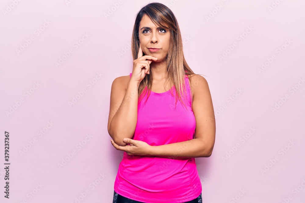 Young beautiful woman wearing sportswear thinking concentrated about doubt with finger on chin and looking up wondering Young beautiful woman wearing sportswear thinking concentrated about doubt with finger on chin and looking up wondering