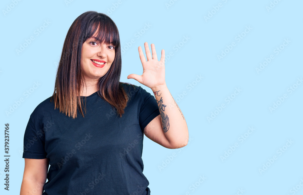 Young plus size woman wearing casual clothes showing and pointing up with fingers number five while smiling confident and happy. Young plus size woman wearing casual clothes showing and pointing up with fingers number five while smiling confident and happy.