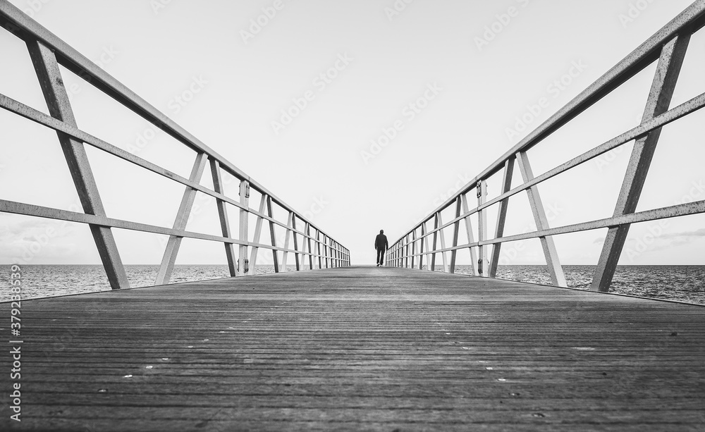 silueta de una persona paseando por un puente