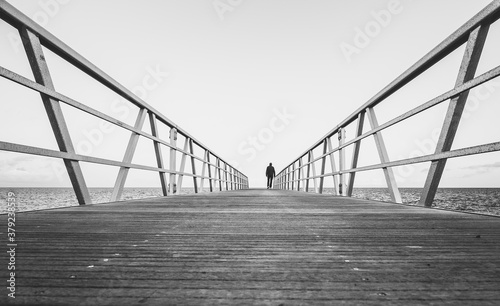 silueta de una persona paseando por un puente