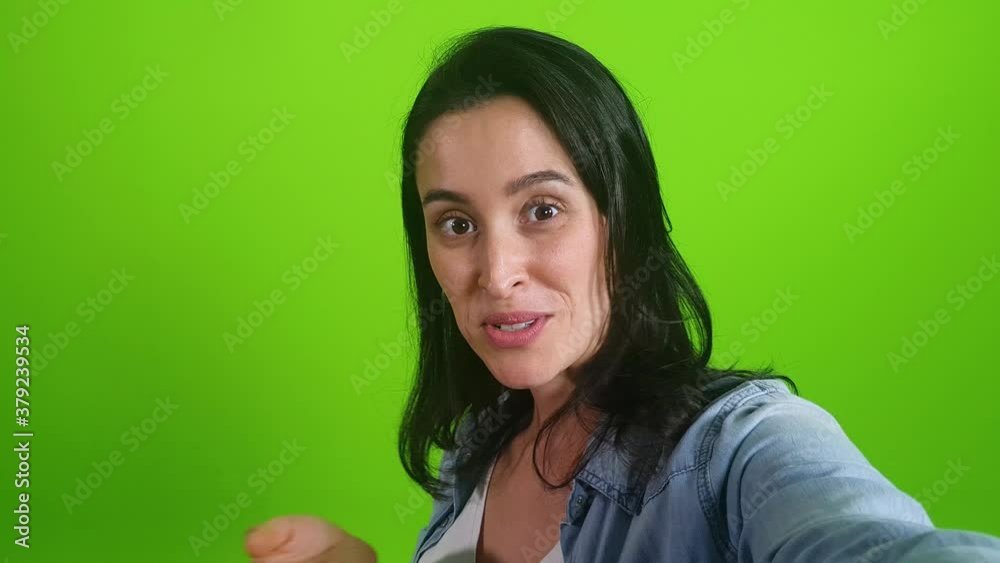smiling woman posing on green screen background. Girl making a video call self portrait photo on smartphone. Chroma key. Female model showing positive face emotions
smiling woman posing on green screen background. Girl making a video call self portrait photo on smartphone. Chroma key. Female model showing positive face emotions