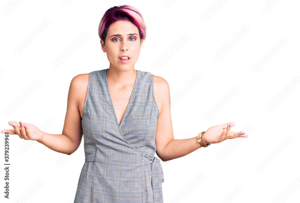 Young beautiful woman with pink hair wearing casual clothes clueless and confused with open arms, no idea concept. Young beautiful woman with pink hair wearing casual clothes clueless and confused with open arms, no idea concept.