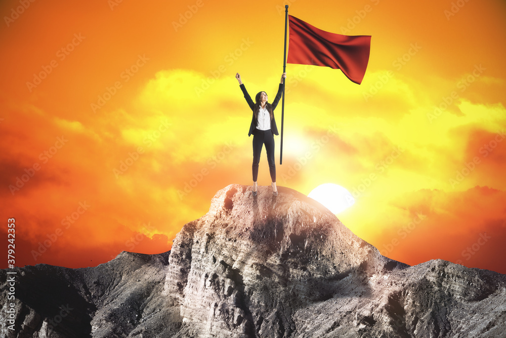 Happy businesswoman with red flag standing on sunset background