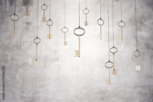 Gold keys on rope on blurry concrete wall background.