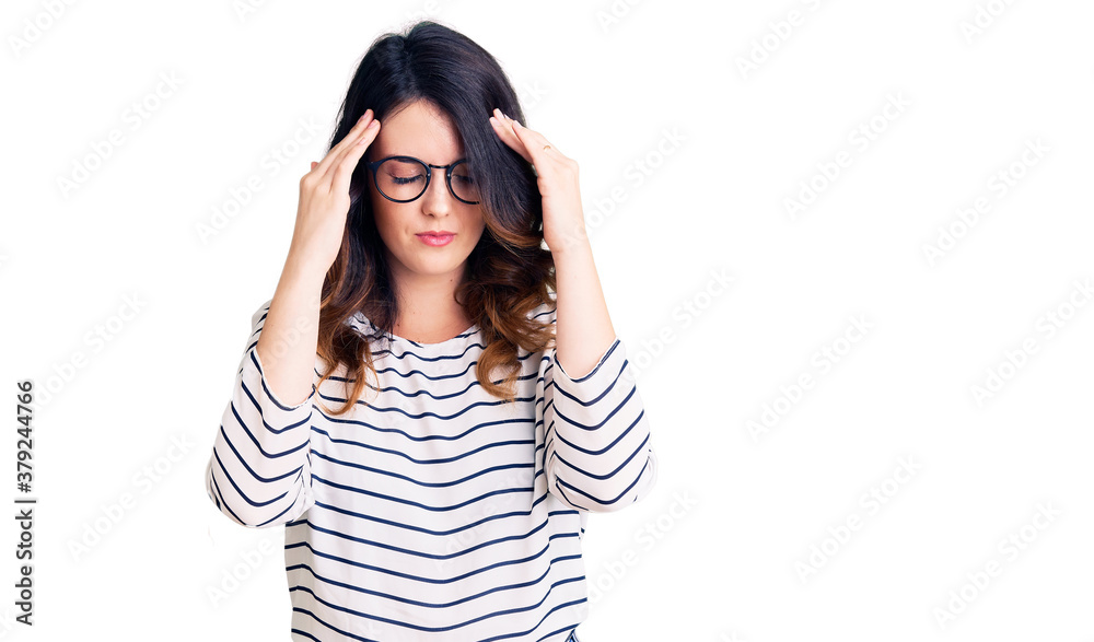 Beautiful young brunette woman wearing casual clothes and glasses with hand on head for pain in head because stress. suffering migraine. Beautiful young brunette woman wearing casual clothes and glasses with hand on head for pain in head because stress. suffering migraine.