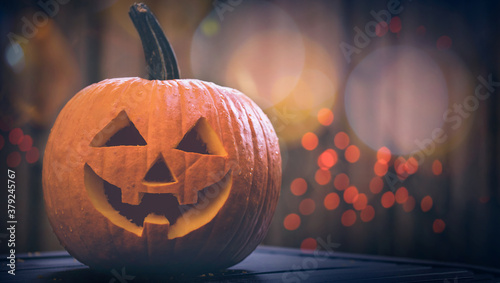 Carved pumpkin on Halloween. Jack O Lantern smile face. Decoration from fresh pumpkins. Autumn Season. Scary Jack-o'-Lantern face. Happy Halloween. Orange lights Bokeh on background.