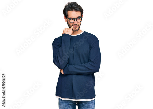 Young hispanic man wearing casual clothes and glasses looking stressed and nervous with hands on mouth biting nails. anxiety problem. © Krakenimages.com